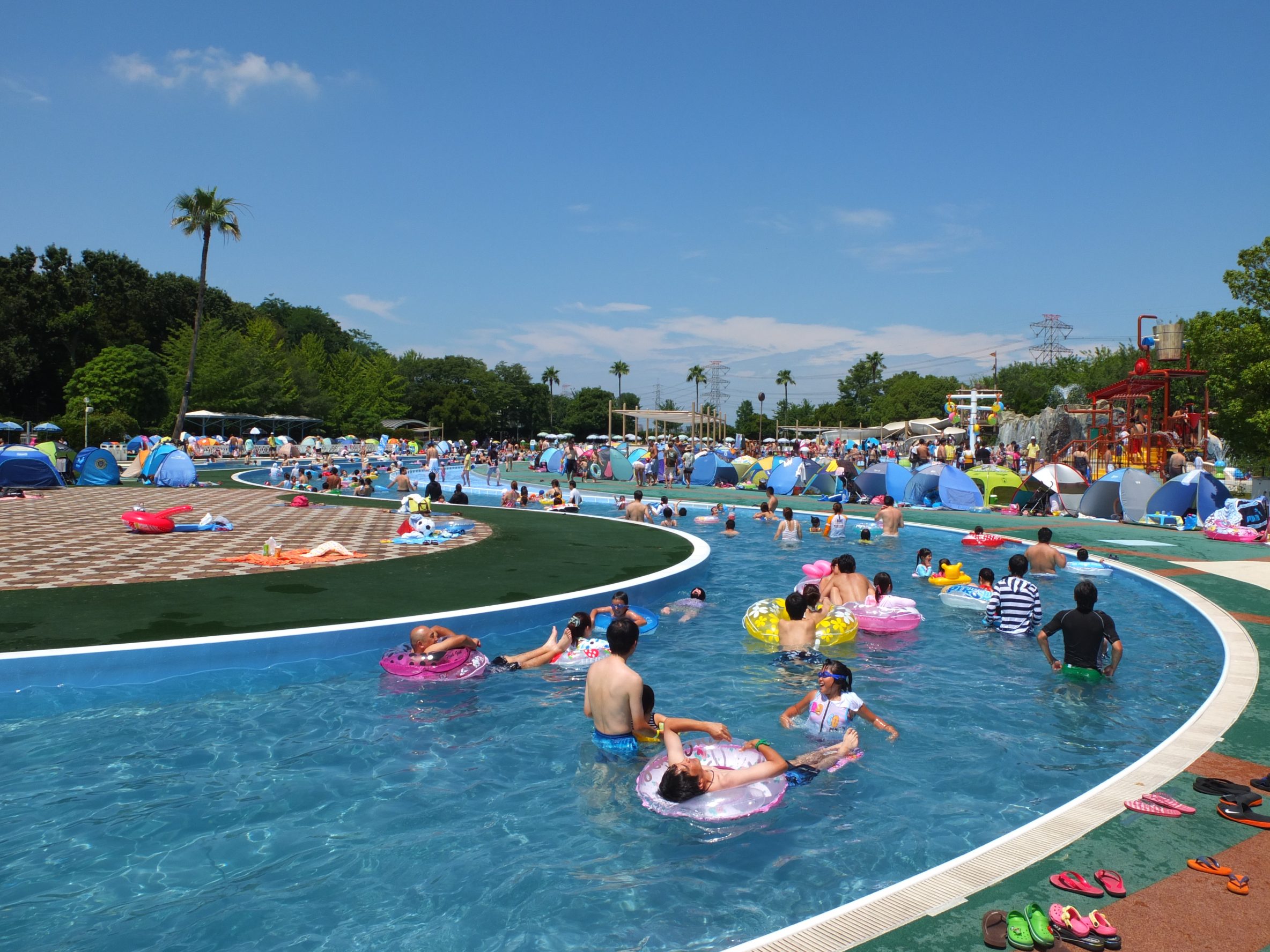 東武スーパープールの流れるプールで遊ぶ家族連れ